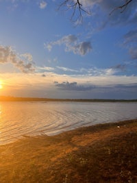 the sun is setting over a body of water